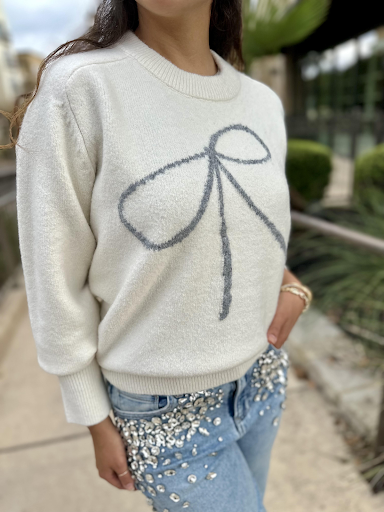 zoomed in photo of six/fifty bow sweater paired with rhinestone denim jeans at san antonio boutique store