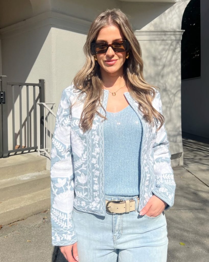 Soft blue embroidery jacket over sleeveless top, paired with light denim jeans and belt